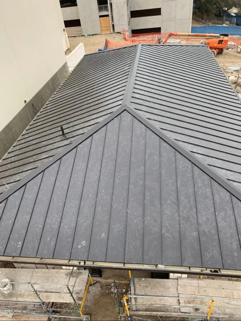 Commercial metal roof construction with crane equipment in Tulare
